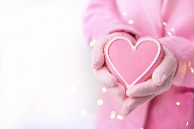 Baking sheet set beside heart-shaped cookies on a kitchen counter in natural light