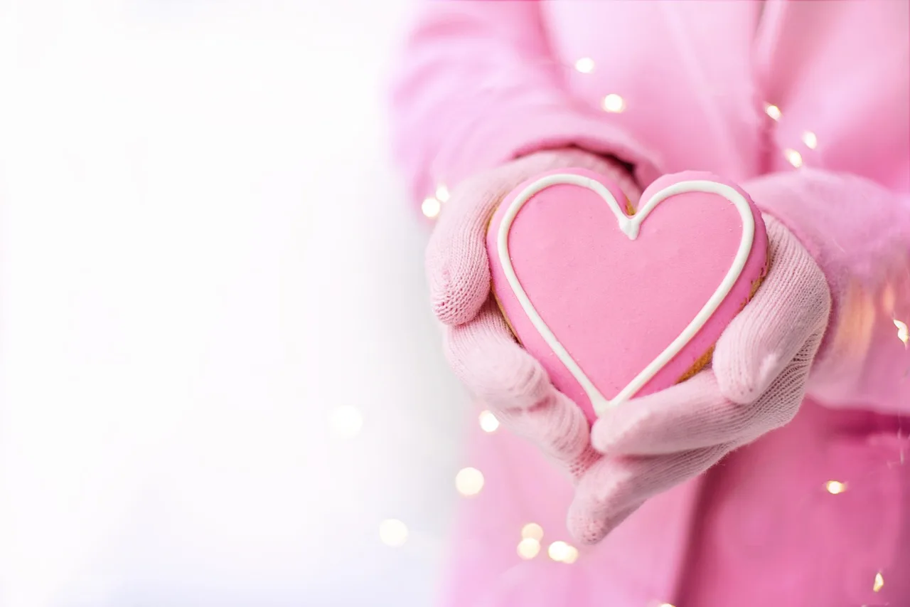 Baking sheet set beside heart-shaped cookies on a kitchen counter in natural light