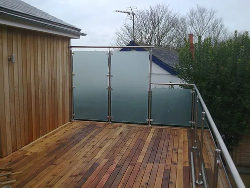 Hands fastening a balcony privacy screen to a railing with ties in close-up.
