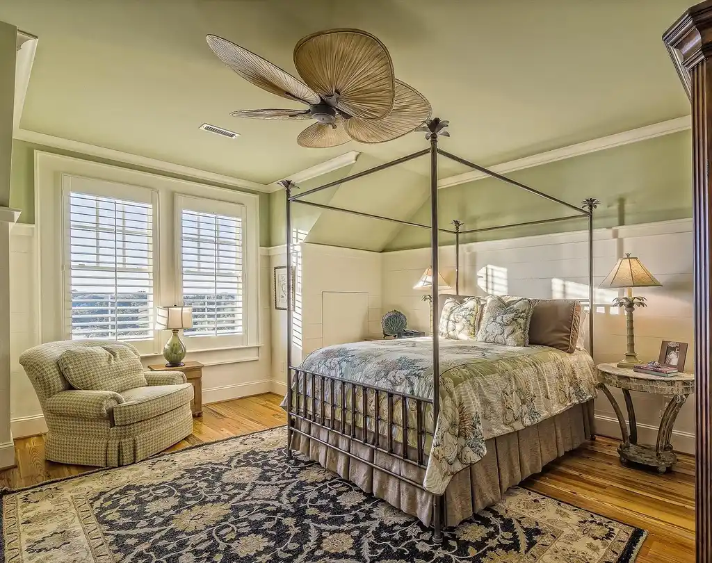 A renter-friendly bedroom with layered bedding, peel-and-stick wall art, and a leaning mirror in natural light.