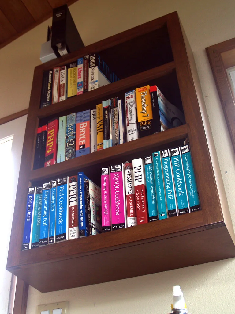 Close-up of hand organizing home office bookshelf shelves and supplies