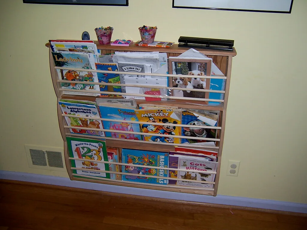 A parent securing a children's bookshelf to the wall with an anti-tip bracket
