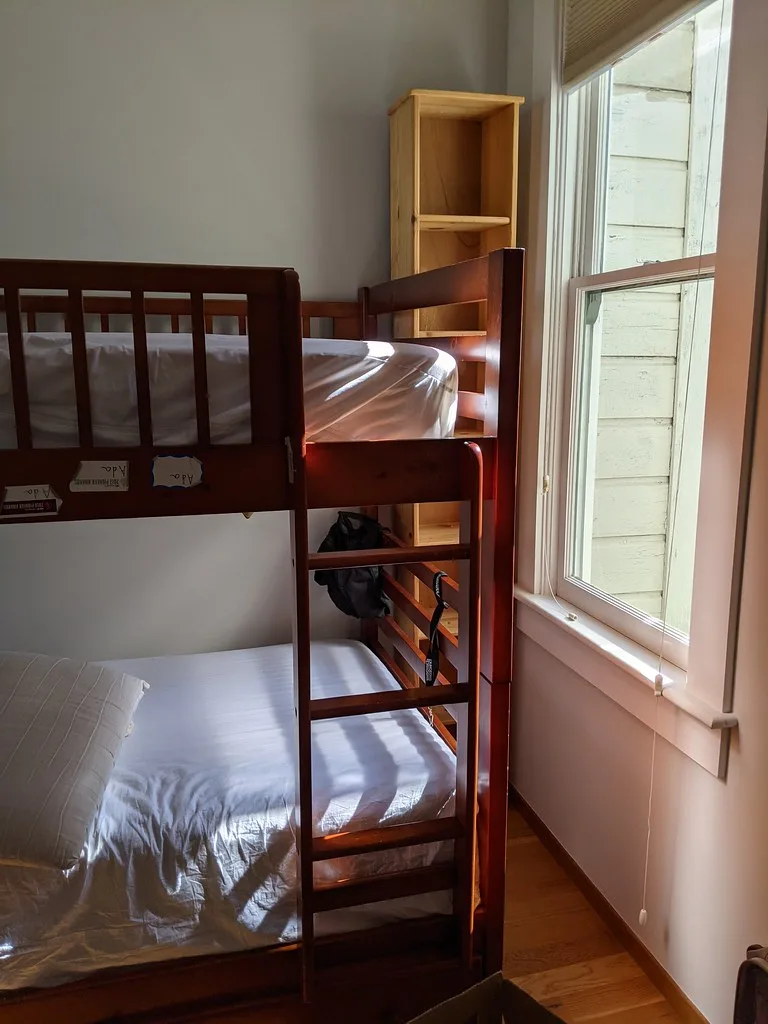Close-up of a freestanding bookshelf with tension hardware and anti-tip straps in a rental apartment