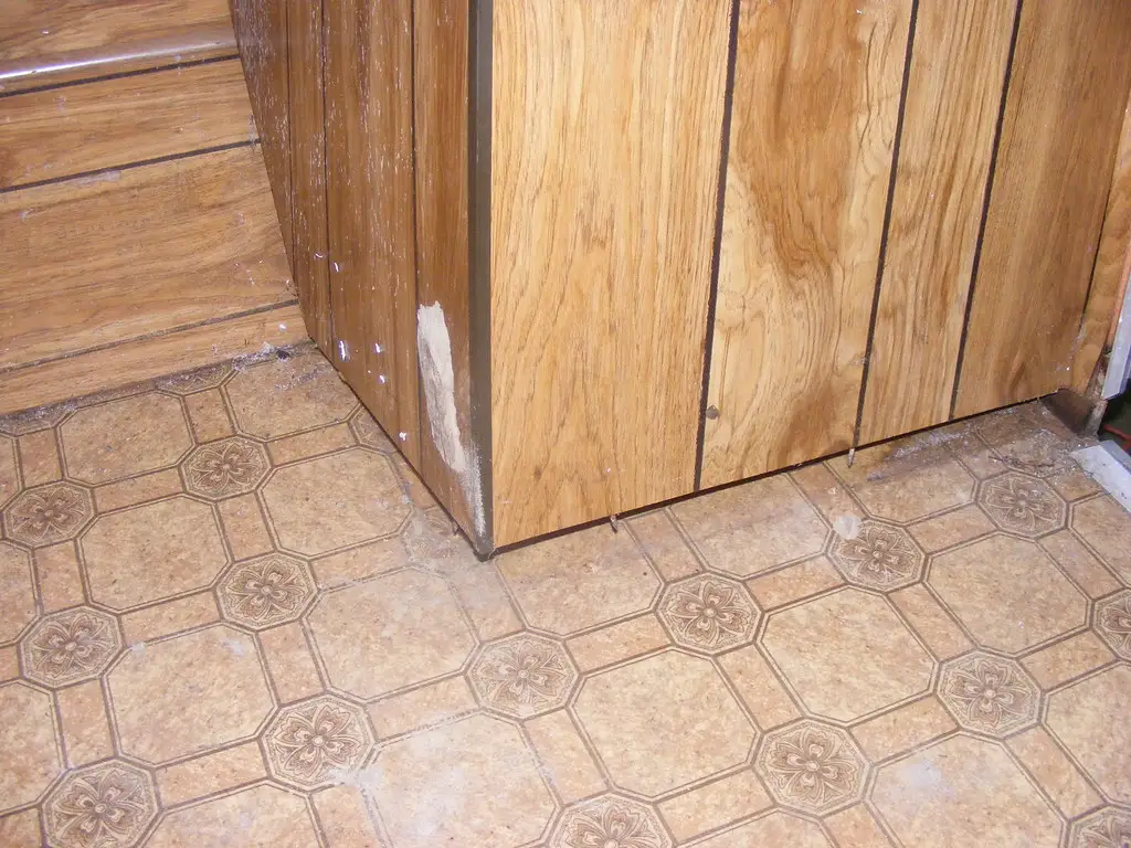 Close-up of a tape measure and cabinet pull beside a drawer front