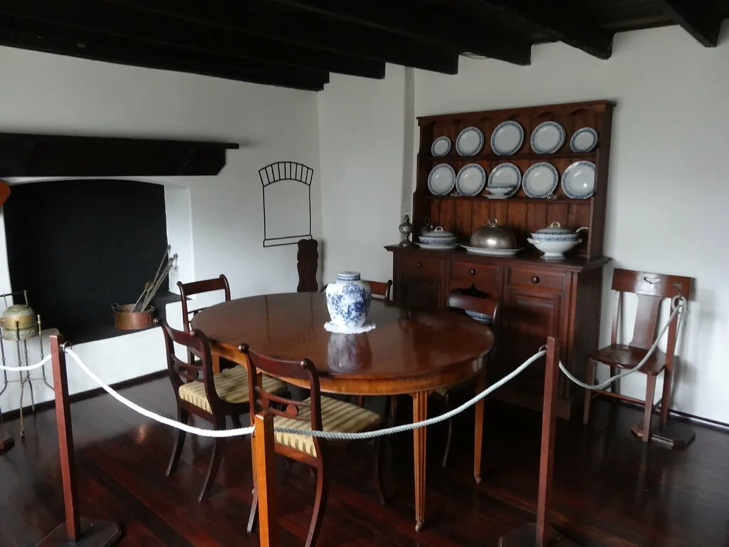 Measuring tape beside a slim dining chair to check clearance in a small dining space.