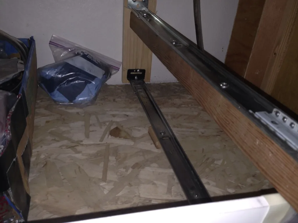 Close-up of a heavy-duty drawer slide being mounted to a cabinet side
