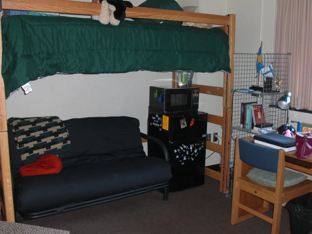 Tape measure across a futon frame to check fit in a small dorm room.