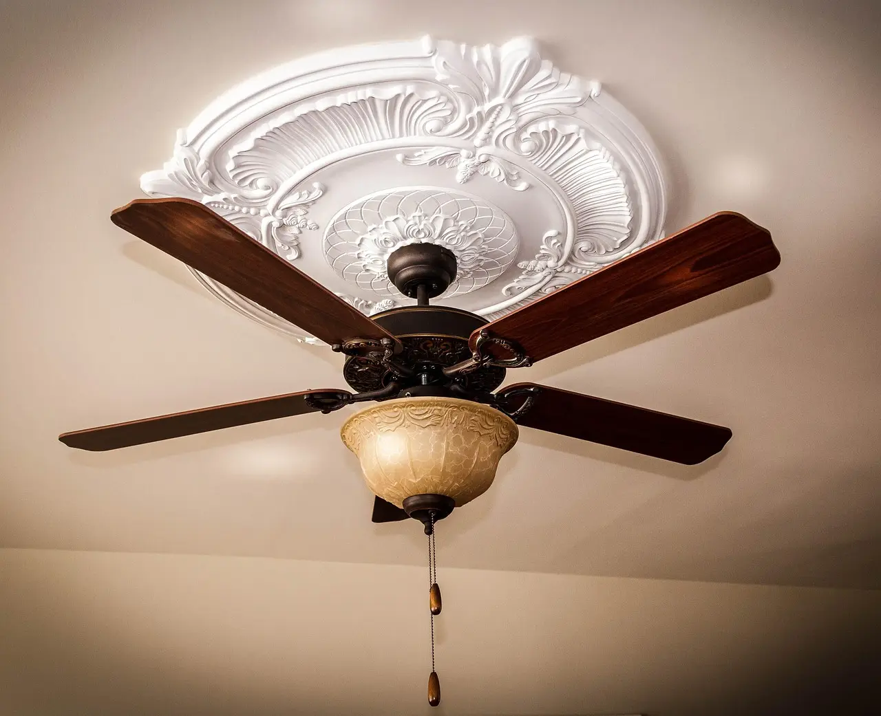 Modern bathroom ceiling light fan above a tiled shower with natural light