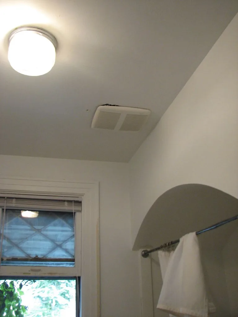 Close-up of a bathroom light fan grille and LED light during installation