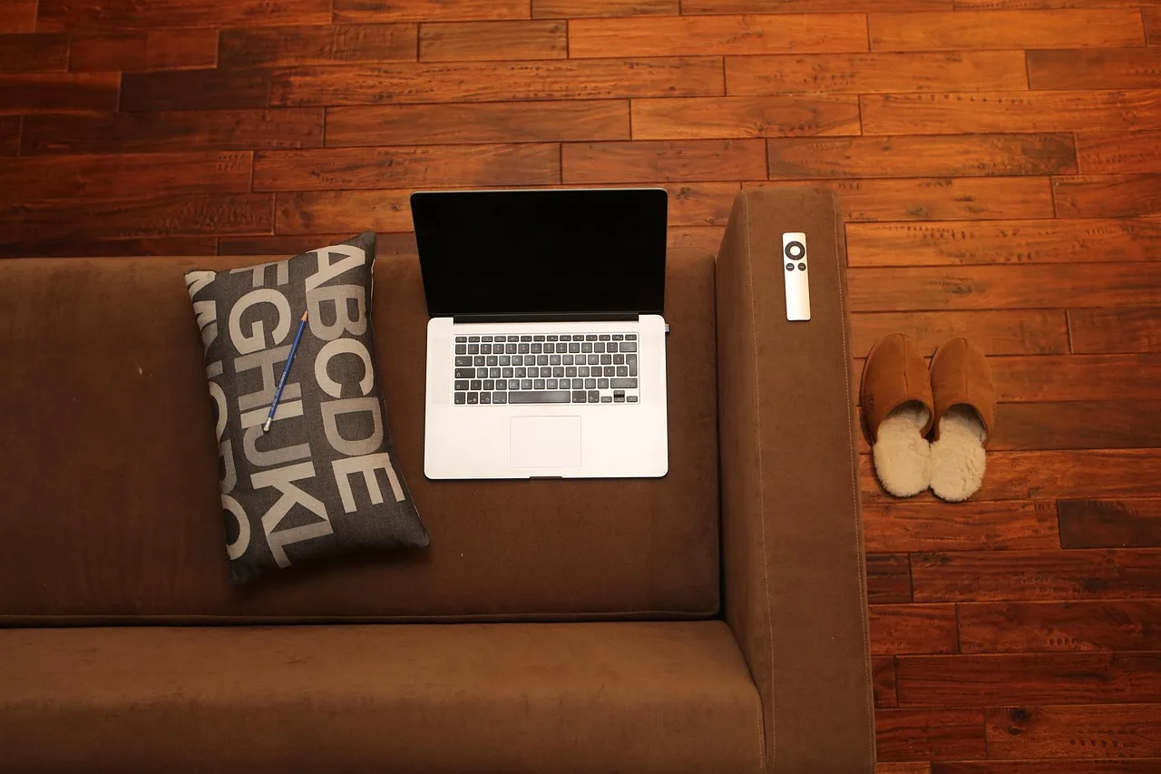 Person treating a fabric couch with upholstery spray in a bright living room