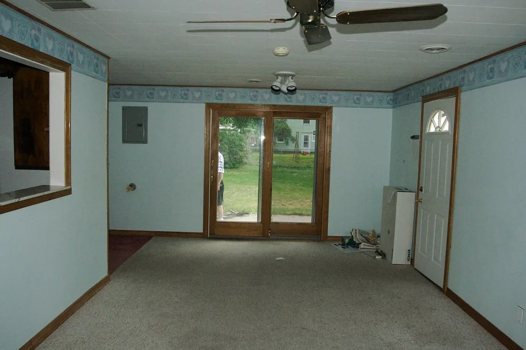 Tape measure beside a ceiling fan and flush light fixture in a small bedroom