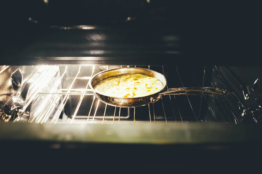 Close-up of a Made In Cookware stainless steel skillet with water beading on the surface
