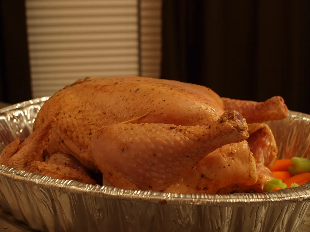 Nordic Ware roasting pan rack with turkey breast and collected juices in close-up