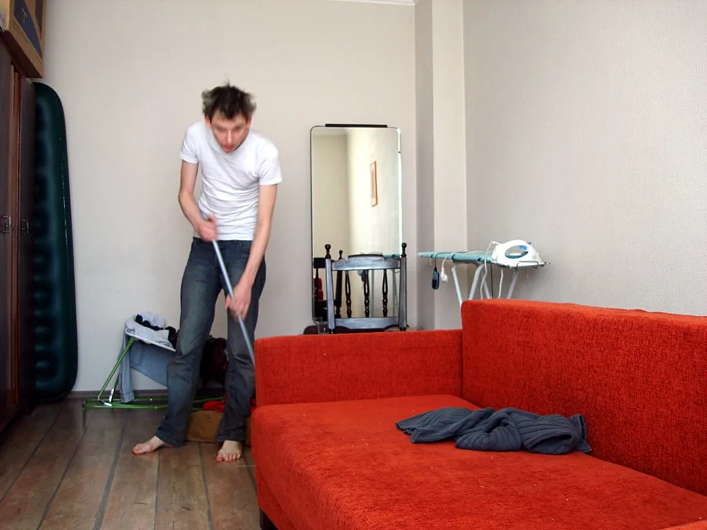 Hand testing upholstery with a white cloth and mild cleaner on a sofa seam