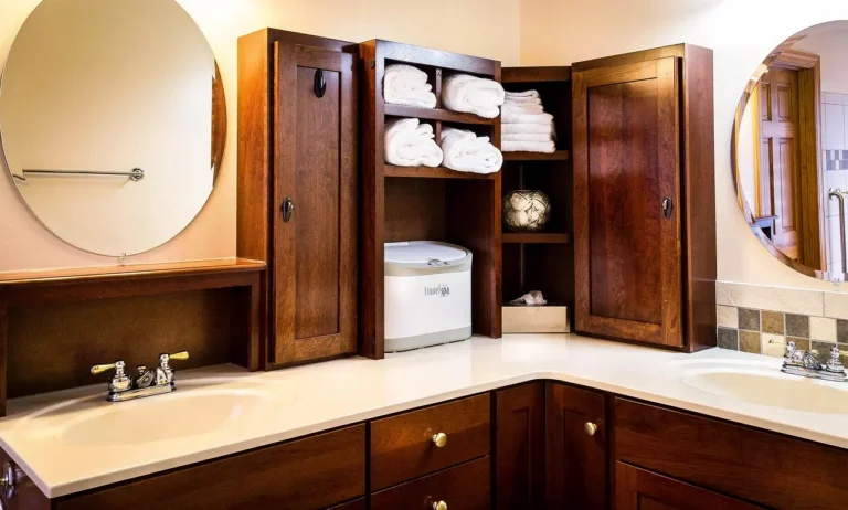Modern bathroom with a storage cabinet beside open shelving holding towels and toiletries