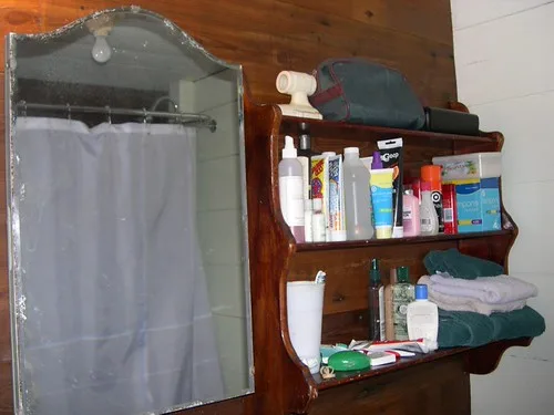 Bathroom open shelf with soap, towels, and skincare arranged for easy reach