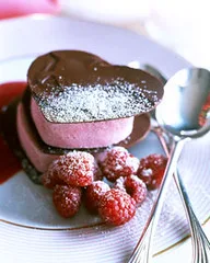 Hands measuring flour and sugar beside strawberries and chocolate for Valentine’s Day desserts