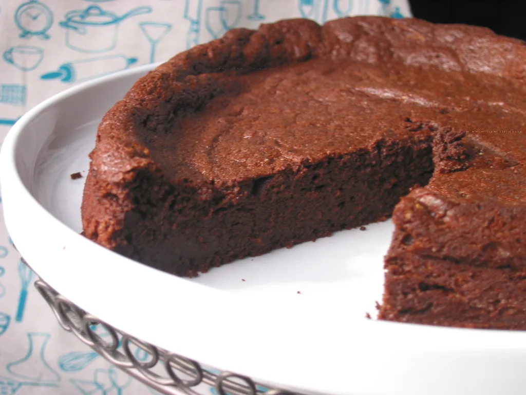 Hand lifting a clean heart-shaped brownie from a lined metal pan