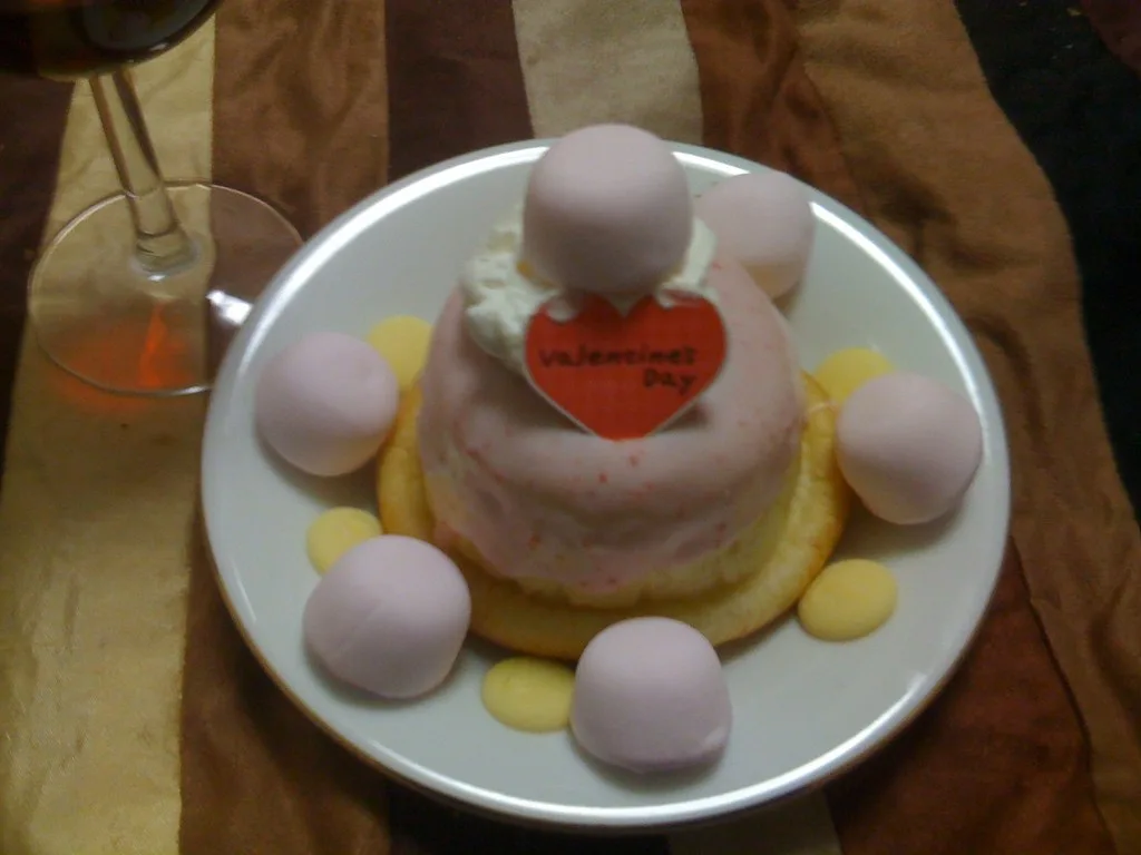 Hands decorating heart-shaped Valentine’s Day cookies with pink icing and sprinkles