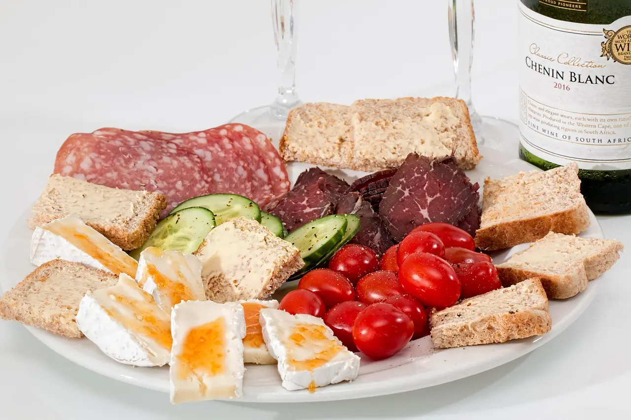 Baked brie on a Valentine’s snack board with crackers, fruit, nuts, and cured meat