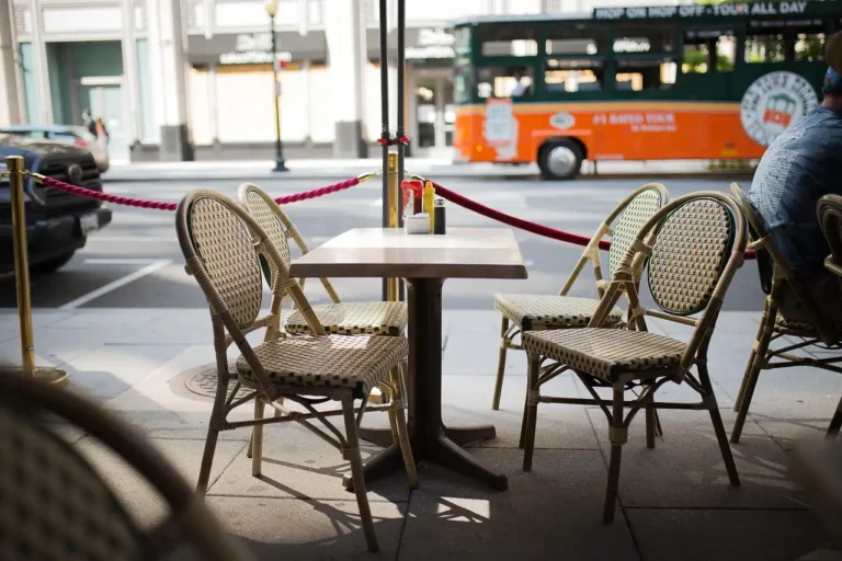 Balcony with folding chairs and bistro chairs beside a small table in natural daylight