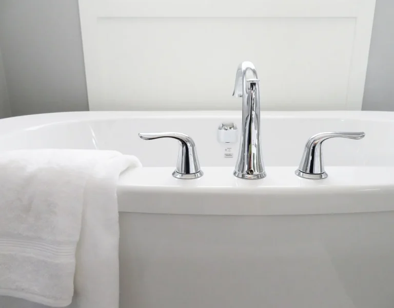 Homeowner and contractor comparing a worn bathtub in a small bathroom with repair materials nearby