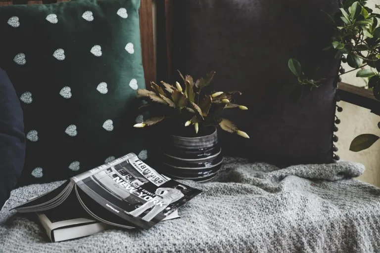 Renter-friendly balcony decor with chairs, plants, rug, and string lights in natural light.