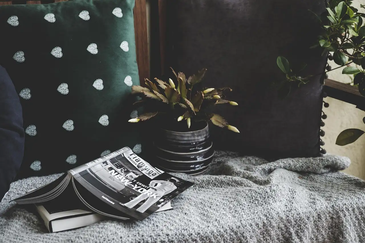 Renter-friendly balcony decor with chairs, plants, rug, and string lights in natural light.