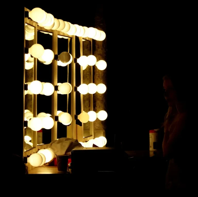 Small bathroom vanity with a narrow mirror and a compact vanity light above it