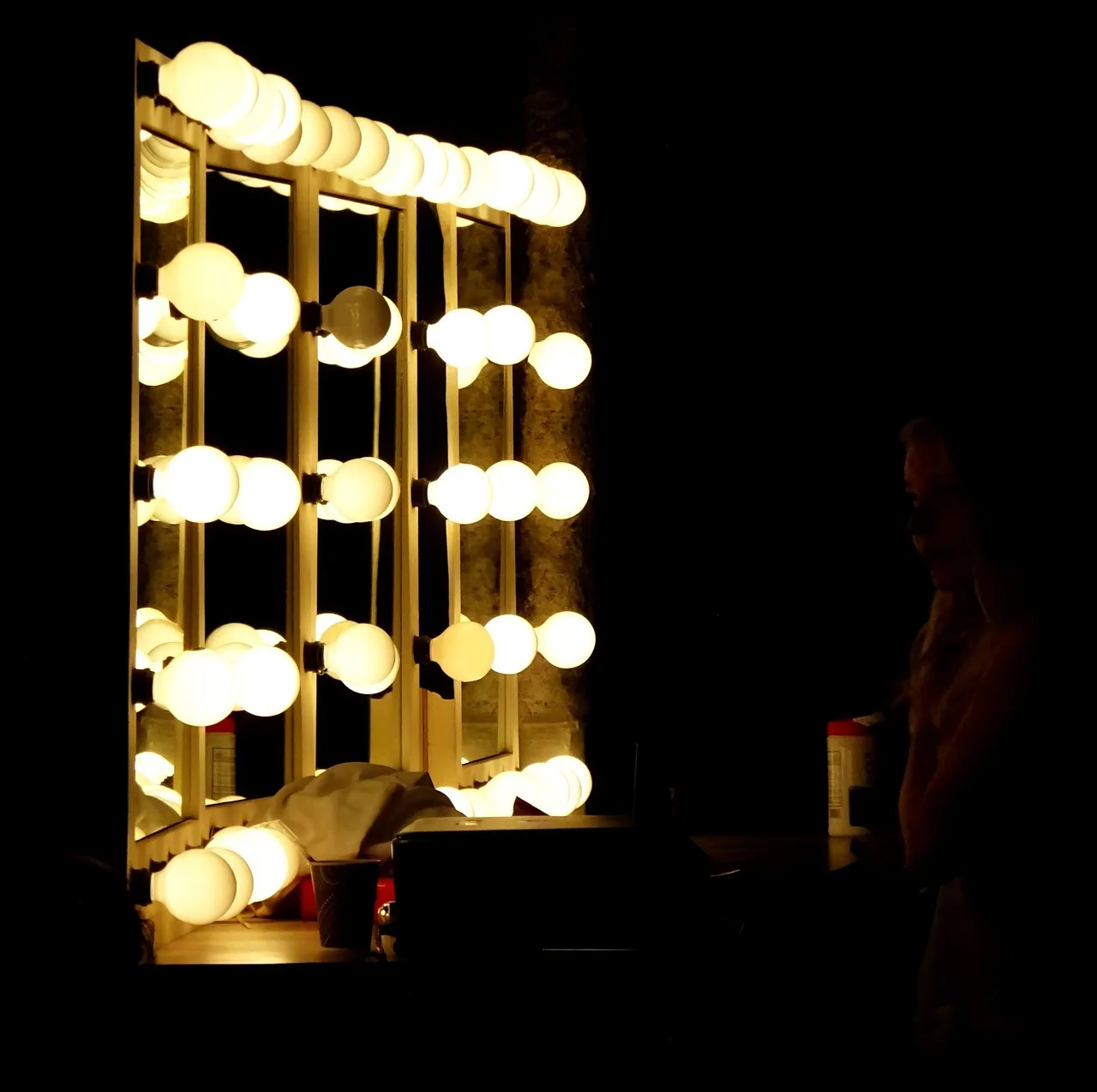 Small bathroom vanity with a narrow mirror and a compact vanity light above it