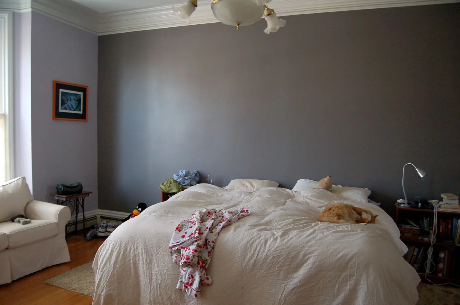 Paint swatches and a wall sample board on a bedside table in natural light