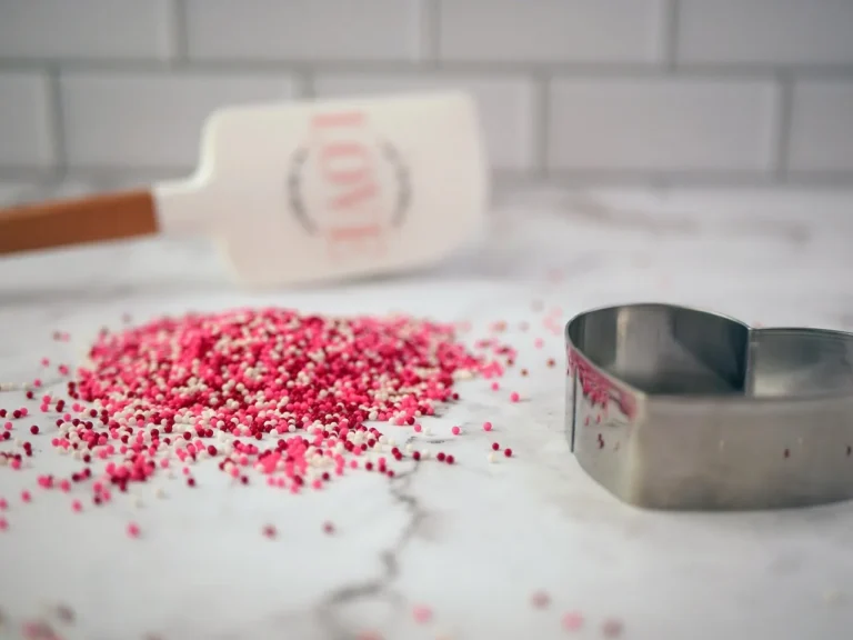 Valentine’s Day desserts with chocolate-dipped strawberries, heart cookies, and melted chocolate on a kitchen table