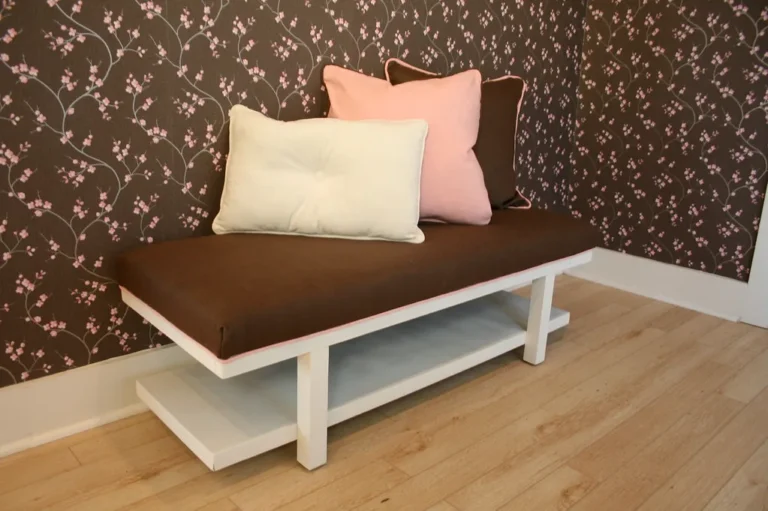 A bedroom with an upholstered foot-of-bed bench placed at the end of a queen bed.