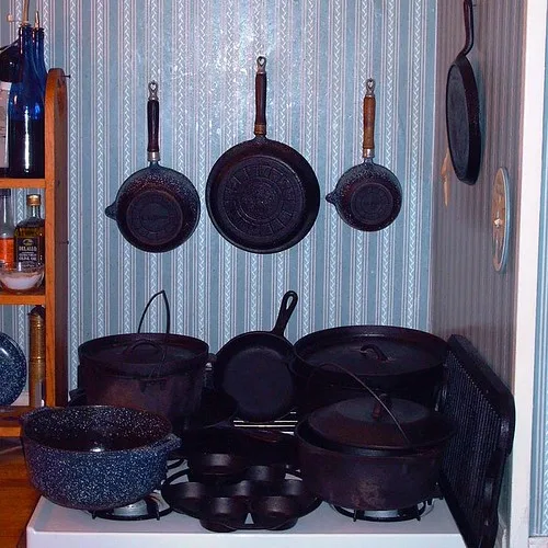 Close-up of a grill pan being lifted and drained over paper towels in a kitchen.