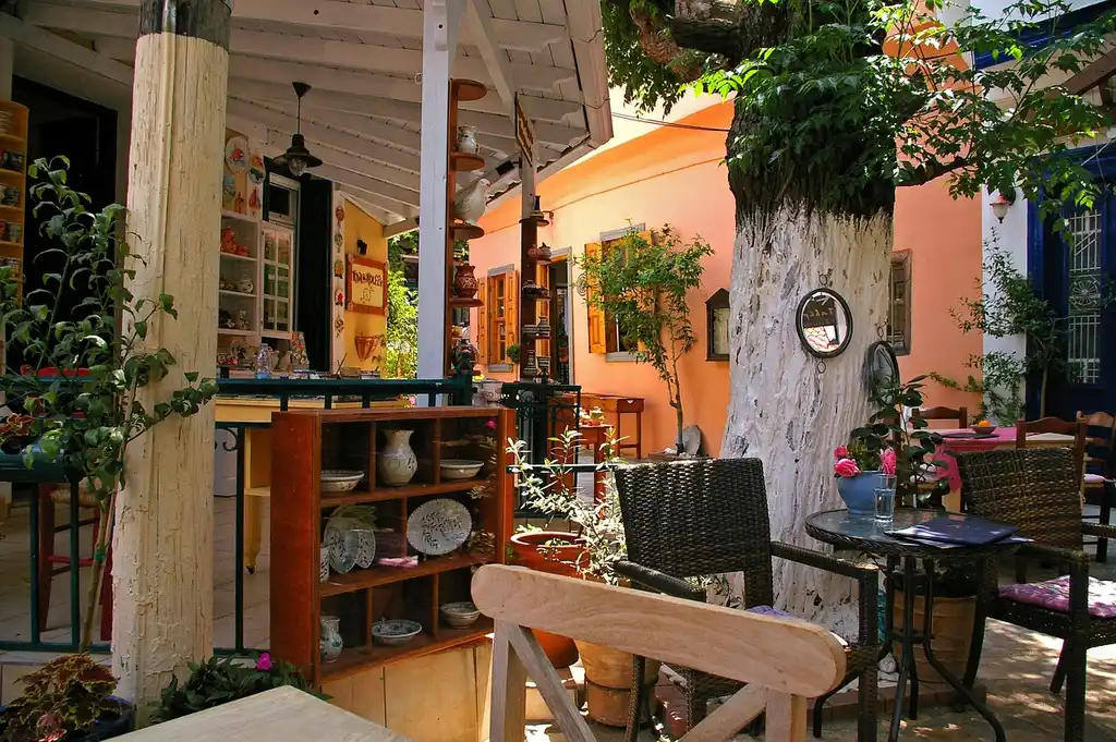 Outdoor furniture in teak, aluminum, and wicker on a sunny patio near the coast
