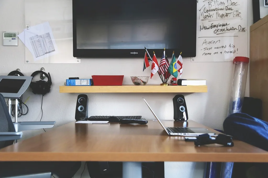 Bestier desk corner with shelf, monitor stand, and neatly routed cables in close-up