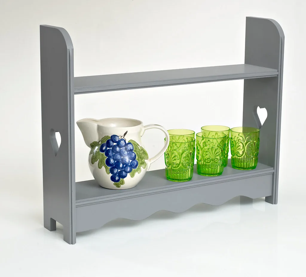 Close-up of a wall shelf holding a few books and a vase on a bracket in a home interior