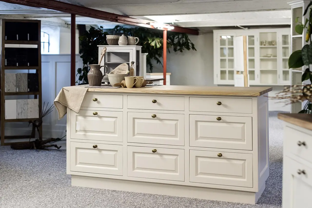 Cabinet organizer inserts laid in an open kitchen drawer while a hand measures fit