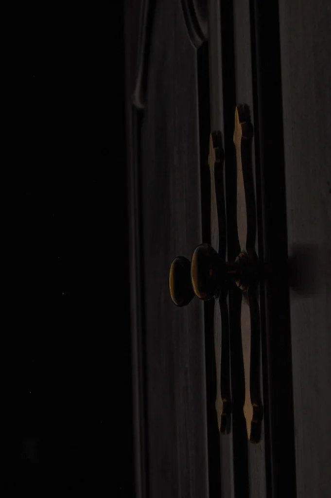 Close-up of a drawer front marked for cabinet pull holes beside a pull and knob