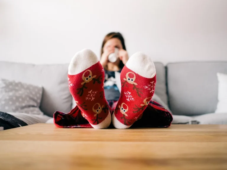 Christmas decor ideas by room in a cozy living room with tree, mantel garland, and wrapped gifts