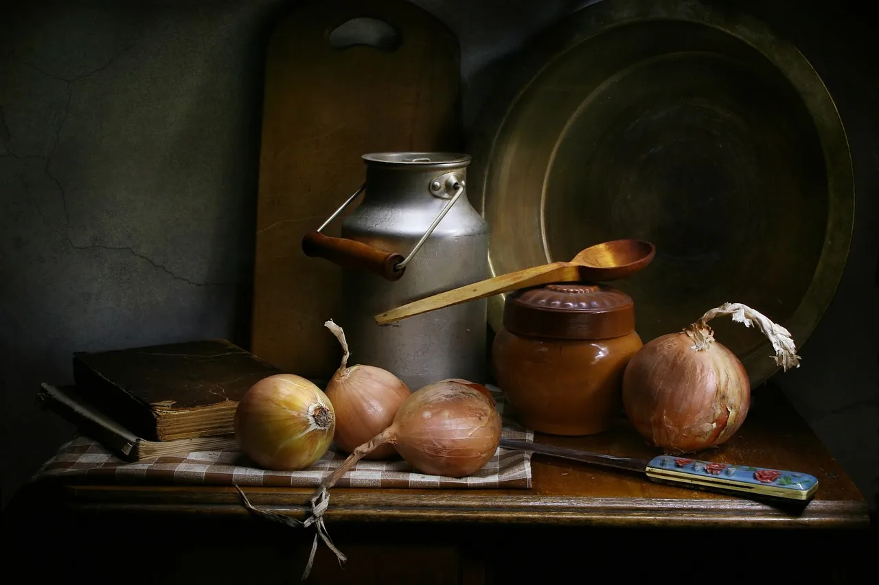 Stainless steel pan beside metal polish, cloths, receipts, and coins on a kitchen counter