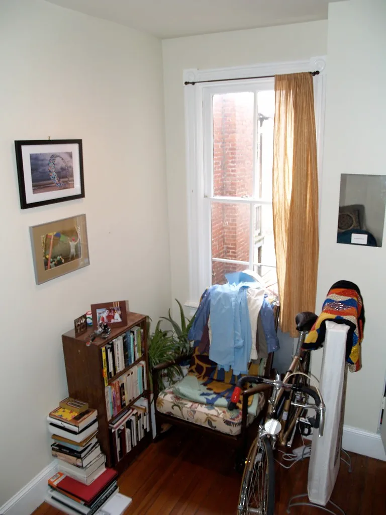 Tape measure checking clearance beside a standard bookshelf near a doorway.
