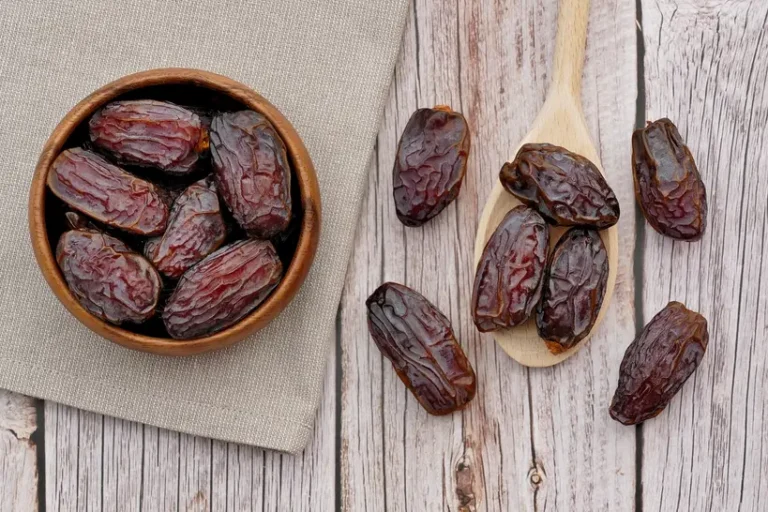 Ramadan table with regular dates and Medjool dates beside water, tea, and nuts