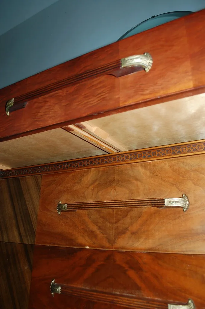 Close-up of a hand installing a metal drawer slide with a screwdriver