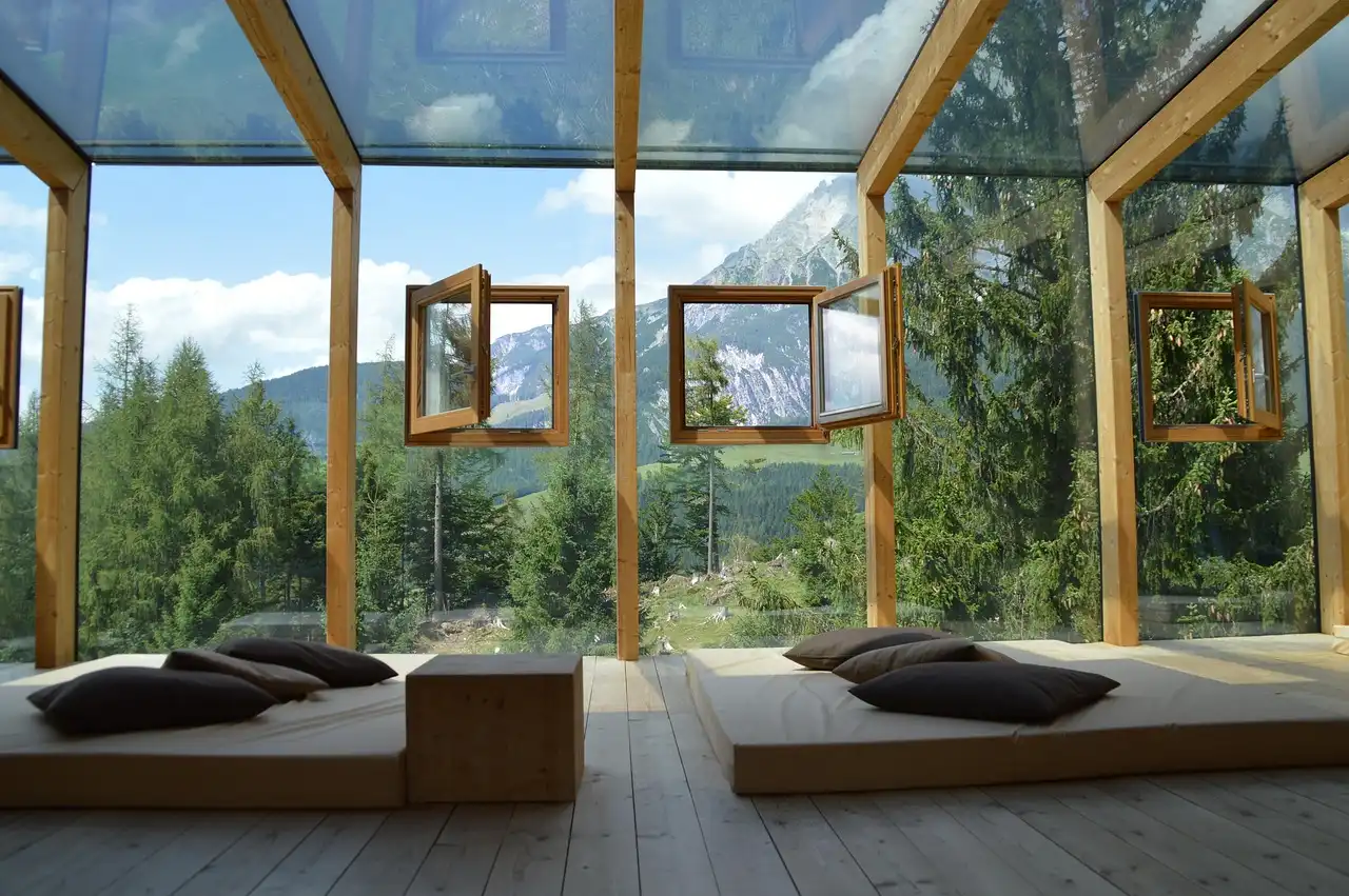 A wooden futon frame with a mattress in a bright living room beside a side table
