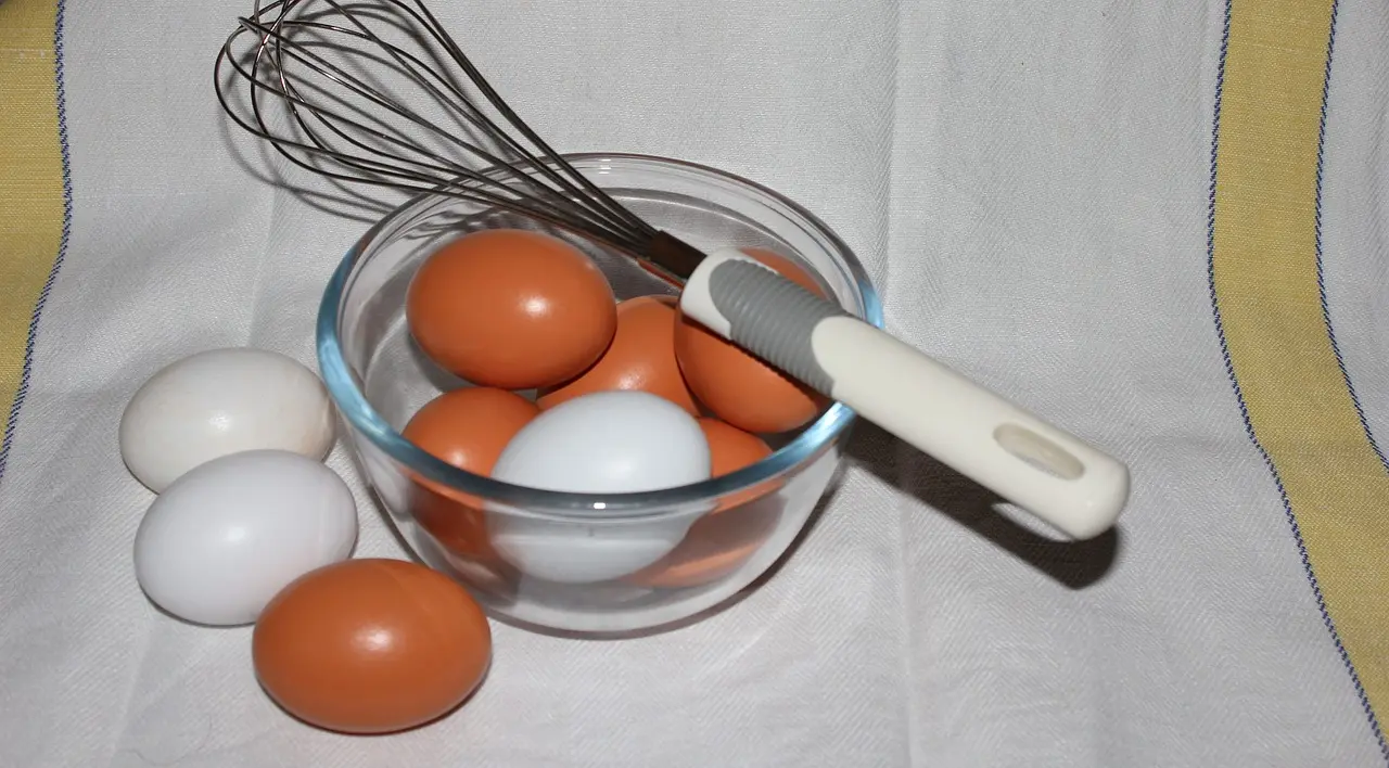 A glass baking dish sits on an oven rack with a casserole inside a home oven