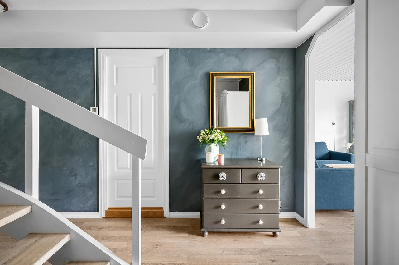 HEMNES dresser in a bright bedroom with a person measuring it beside folded clothes