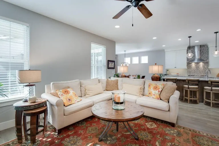 Home Decorators Collection ceiling fan above a bright living room with sofa and natural light