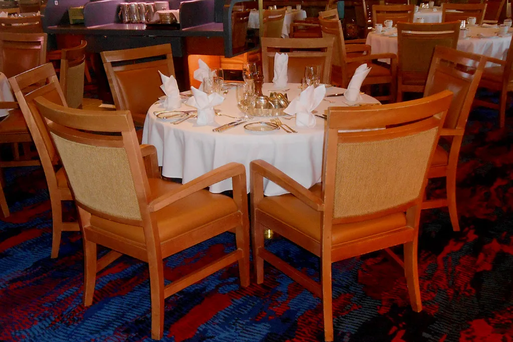 Close-up of a dining table corner being protected with foam, bubble wrap, and crate slats.