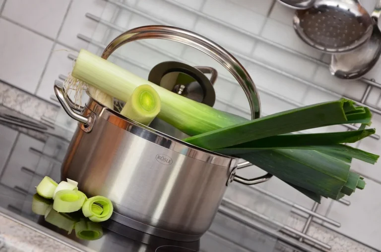 Pot and pan organizer in a kitchen cabinet with stacked cookware and a tape measure